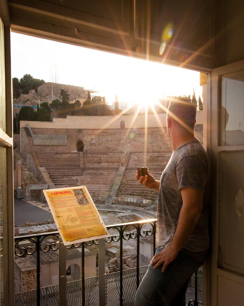 丹站在一间公寓的窗户上，看着窗外的罗马剧院