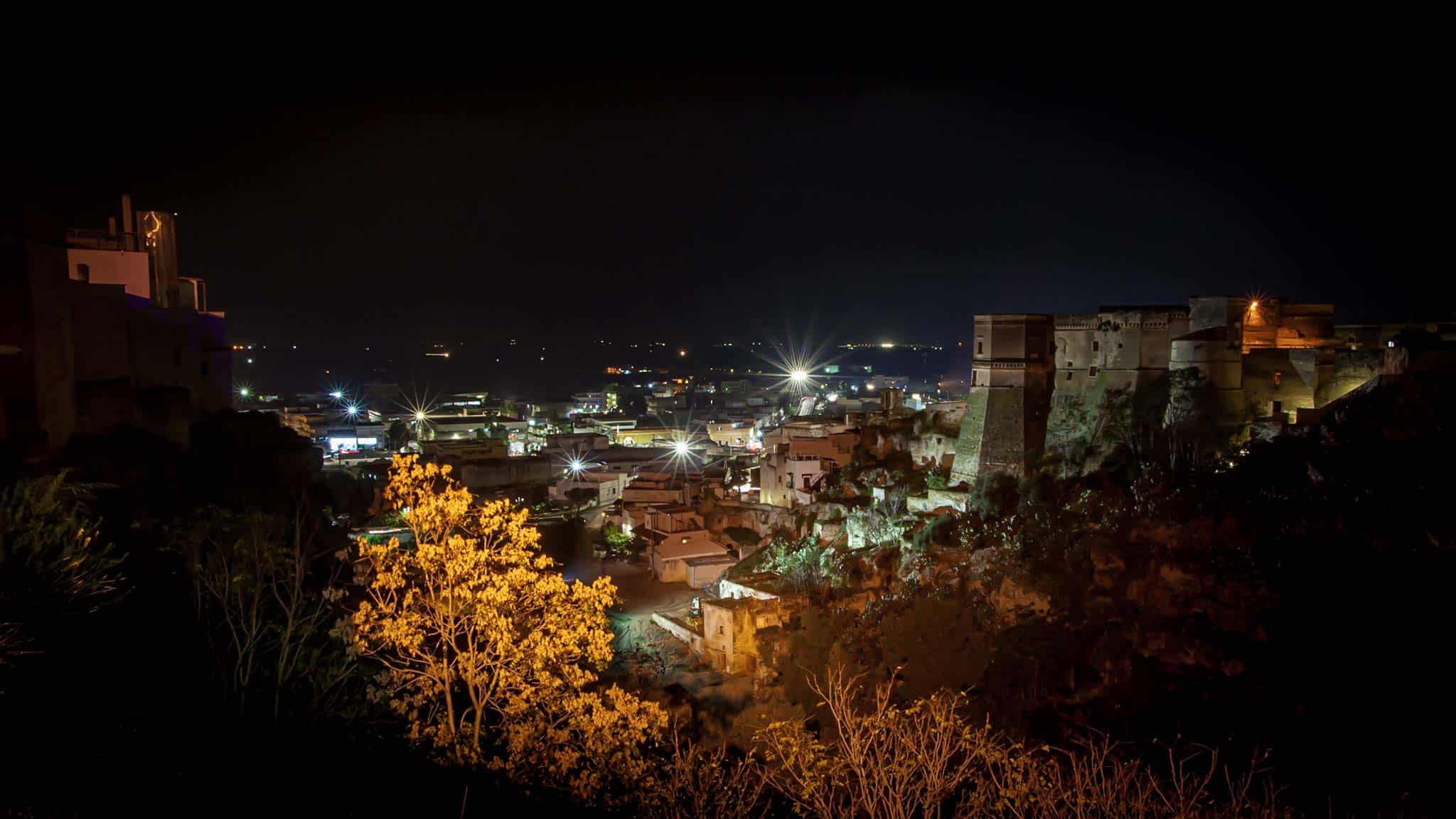 晚上，右边的城堡坐落在下面的普利亚镇之上