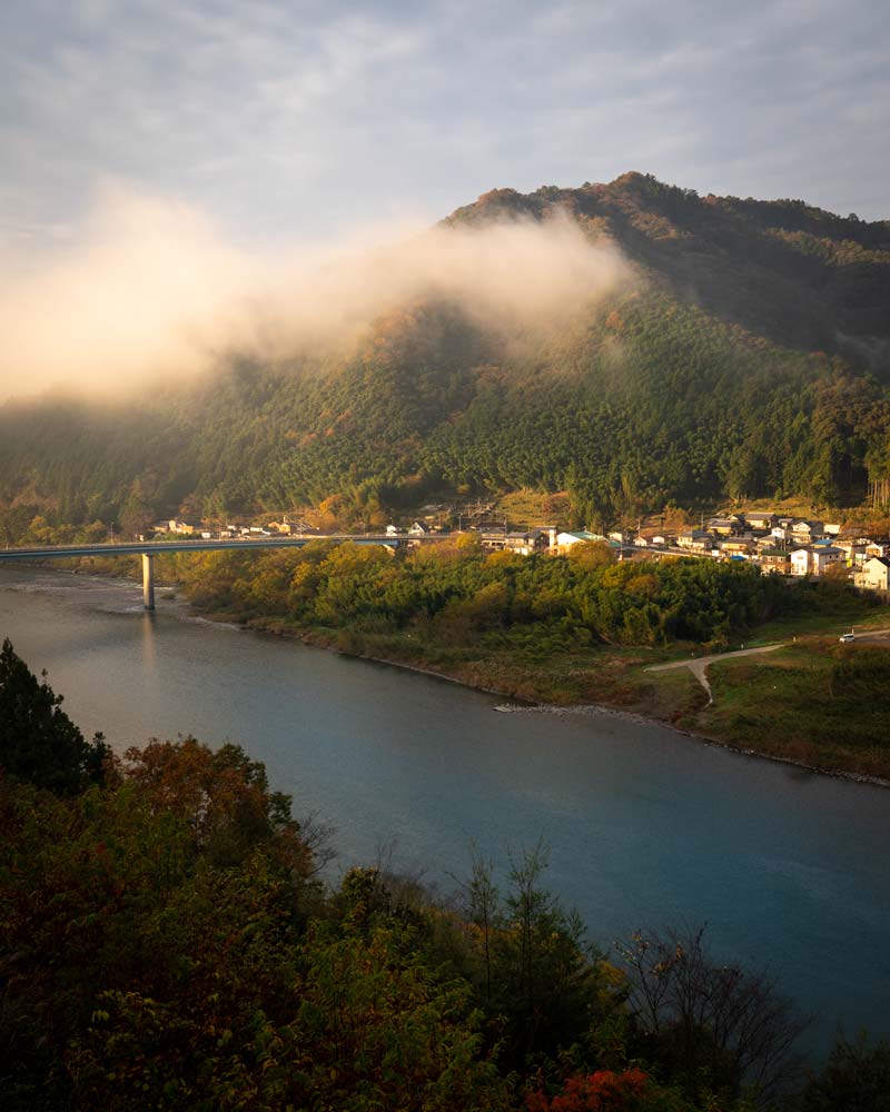 日出时的石门托河，云层漂浮在村庄上空