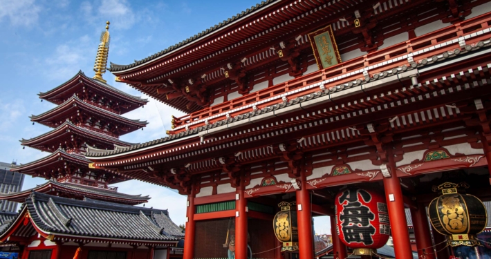 在东京，一座美丽的红色宝塔坐落在一座巨大的红色寺庙旁边