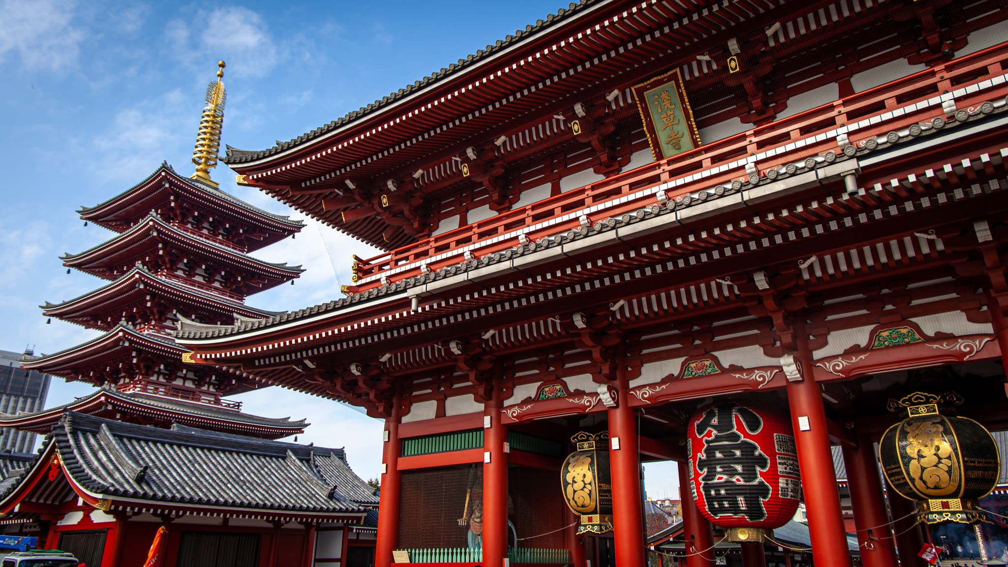 在东京，一座美丽的红色宝塔坐落在一座巨大的红色寺庙旁边