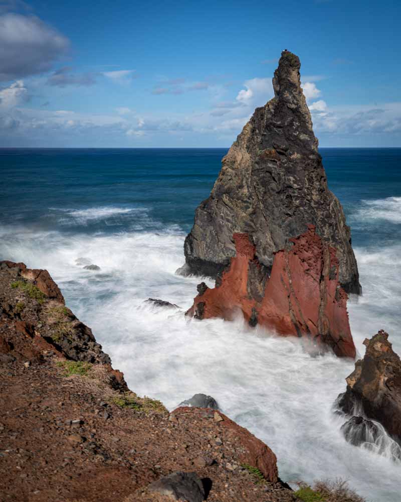 在一张长时间曝光的照片中，海浪撞击着岩石，水在岩石周围呼啸而过